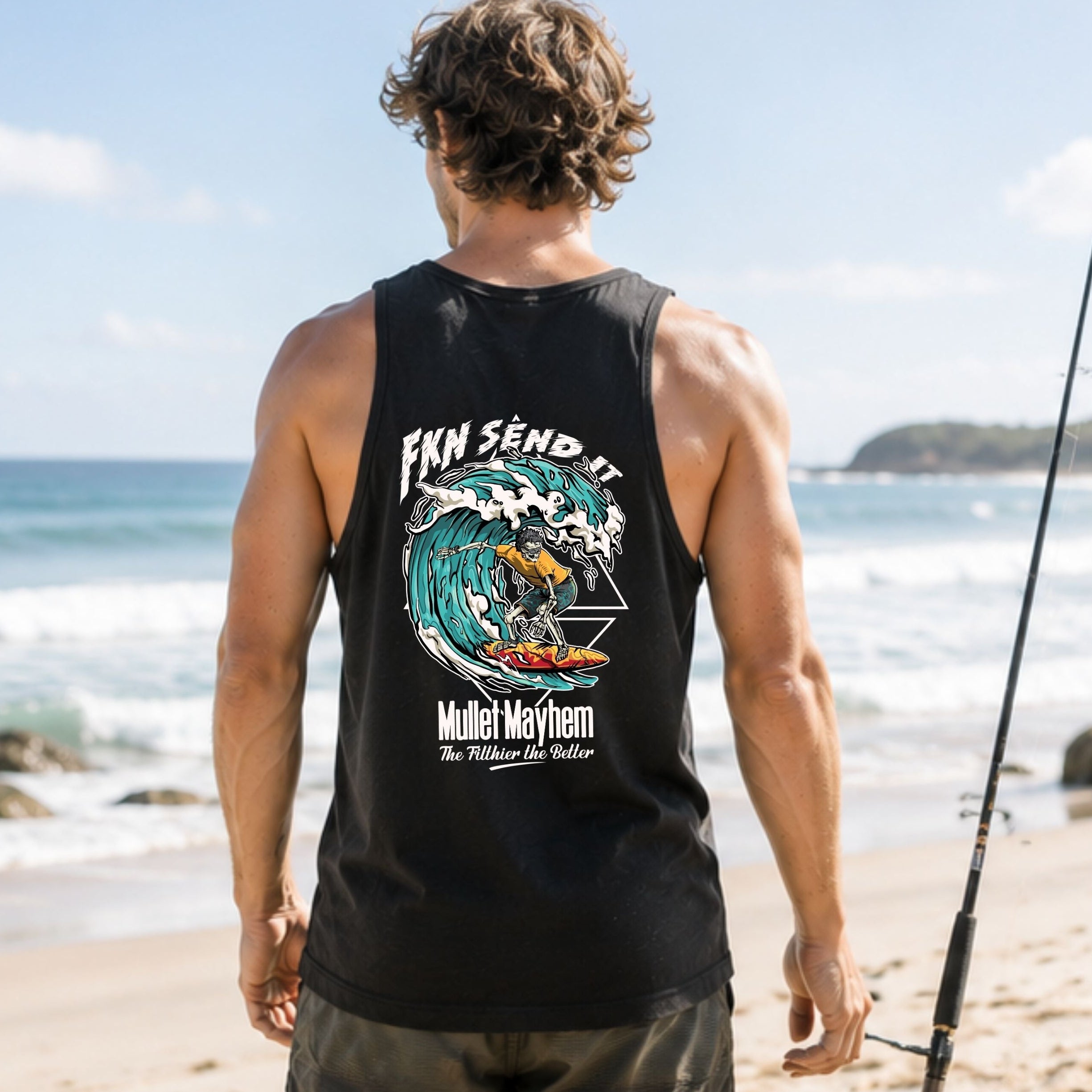 A man standing on a beach facing away from the camera, wearing a black tank top with a large graphic print on the back. The graphic features a wave illustration and the text 'I Can Send It' and 'Mullet Heyhem'.