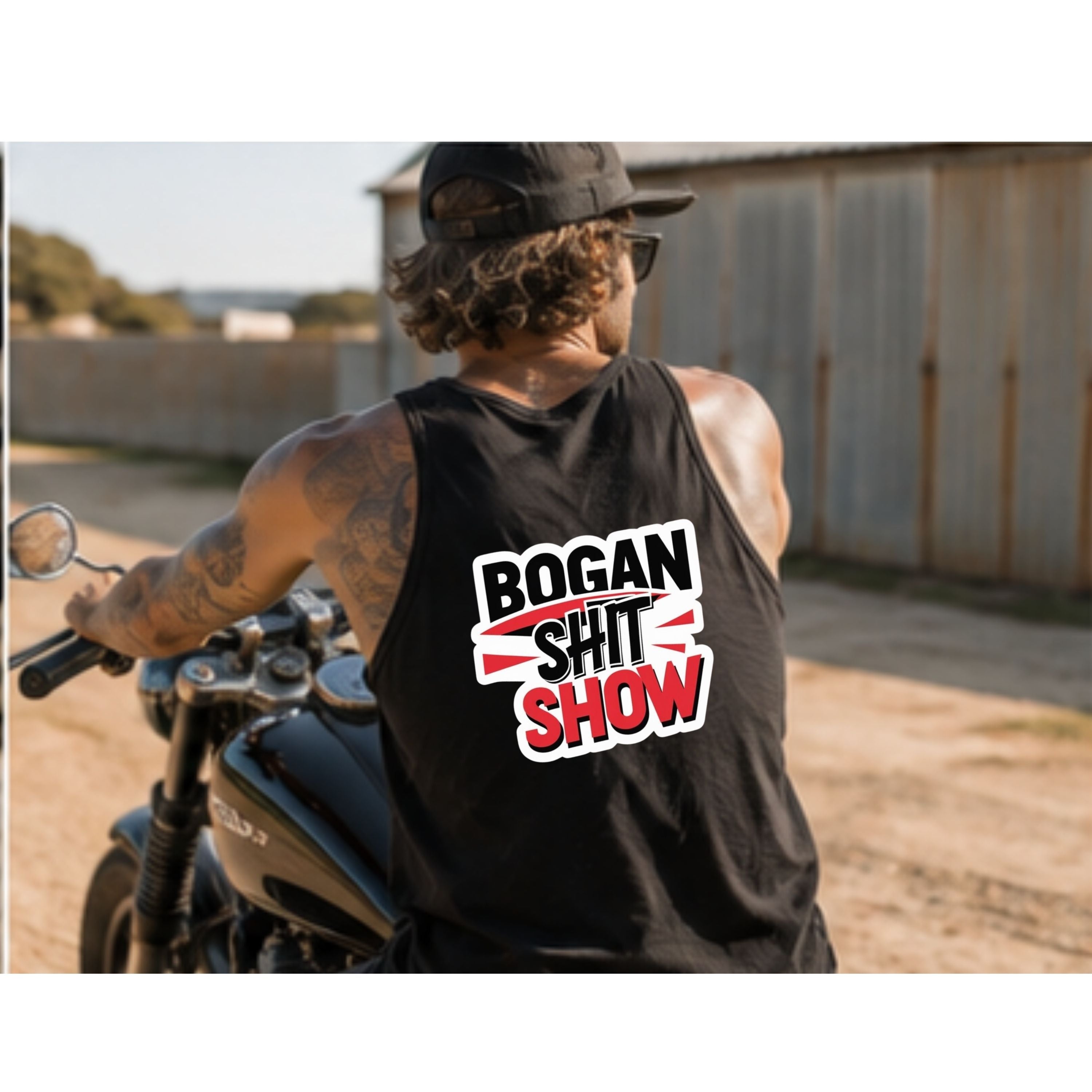 A man wearing a black tank top with a bold graphic that reads 'BOGAN SHIT SHOW' in white and red, photographed from behind while sitting on a motorcycle in an outdoor setting.